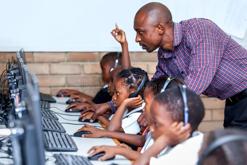 Teacher guiding students on computer use